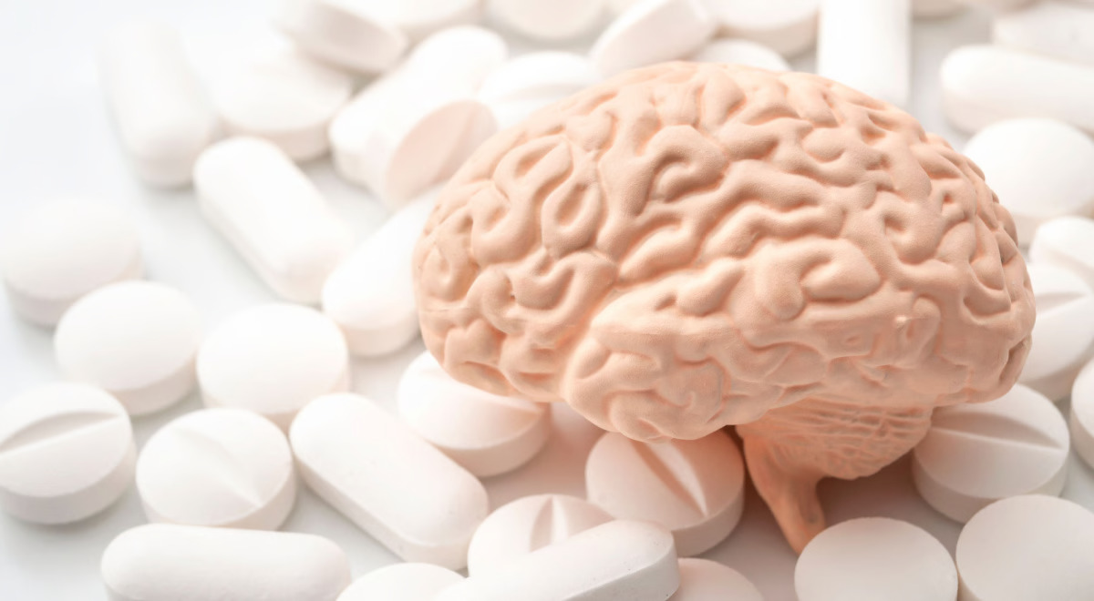 a photo with tablets in background and a brain in the middle, illustrating nootropic tablets